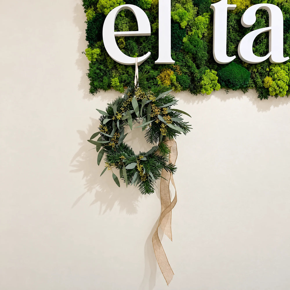 Corona de Navidad natural de eucalipto sobre pared vegetal, La Plantisserie Gràcia (Barcelona)