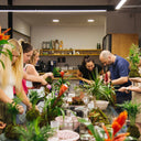 Team building entre plantas en Barcelona: equipo creando piezas botánicas en un taller de La Plantisserie